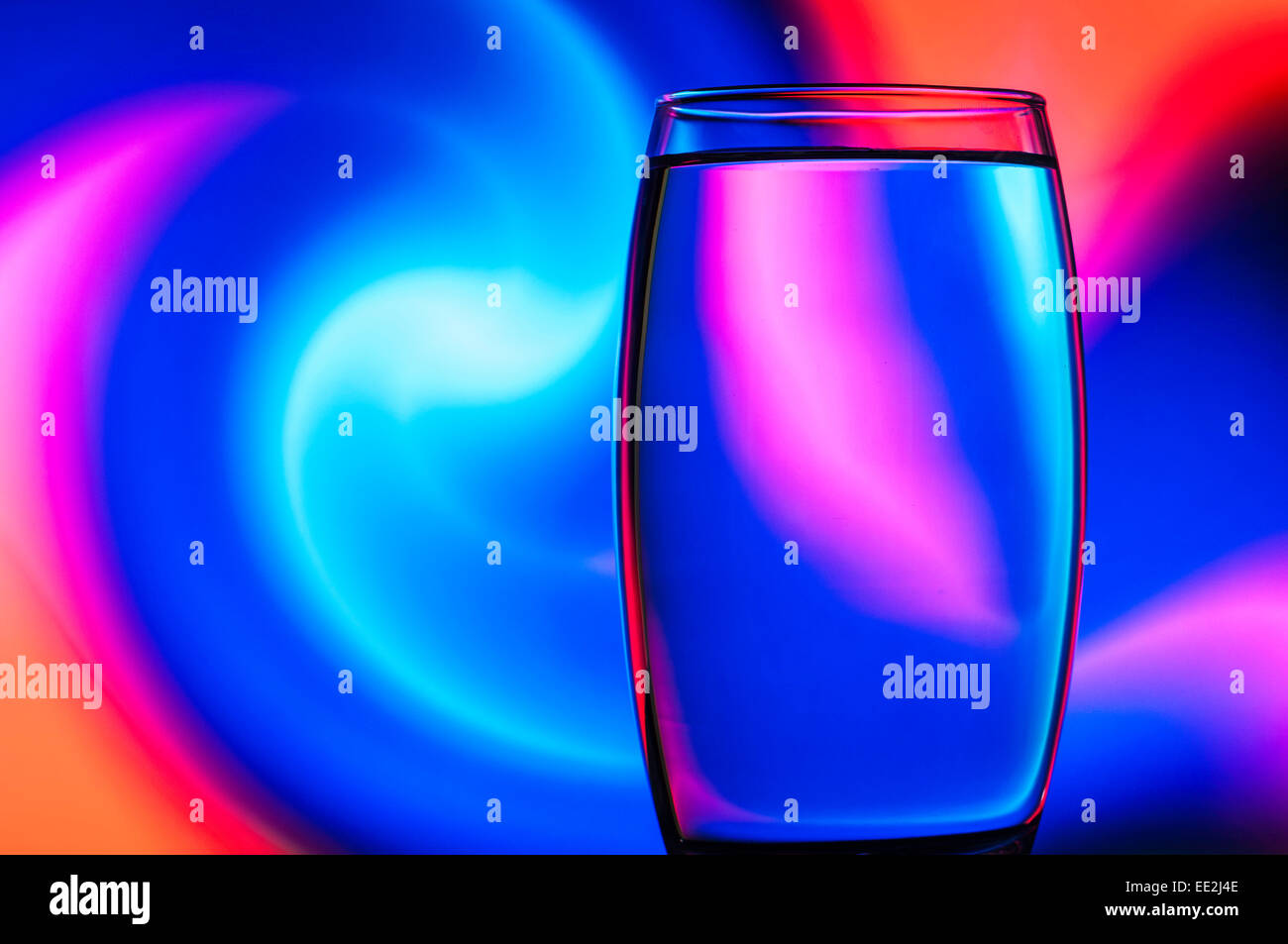 A tumbler of water against a patterned background to illustrate the refractive effect of water