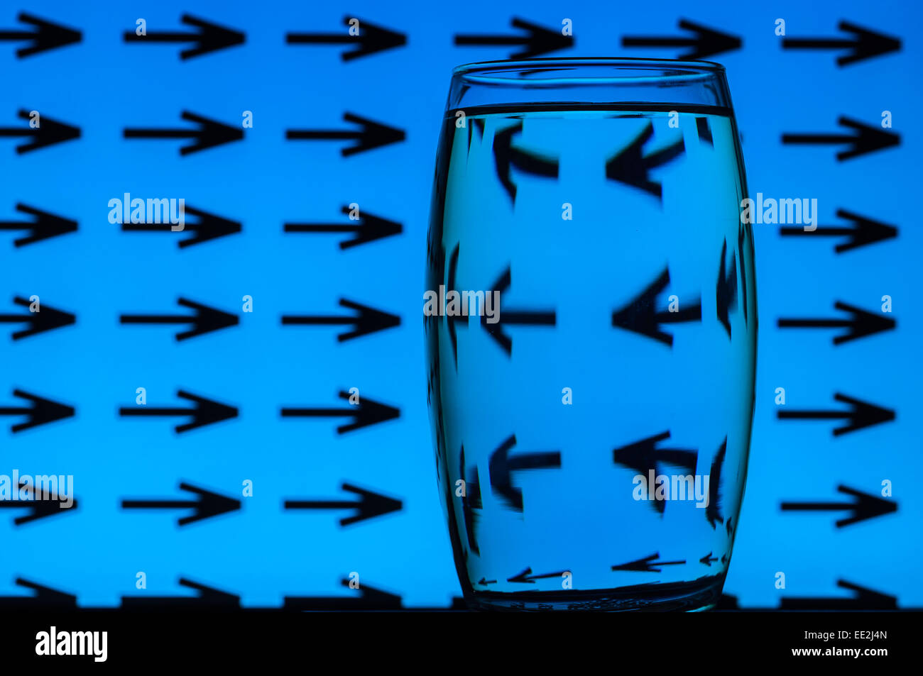 A tumbler of water against a patterned background to illustrate the refractive effect of water