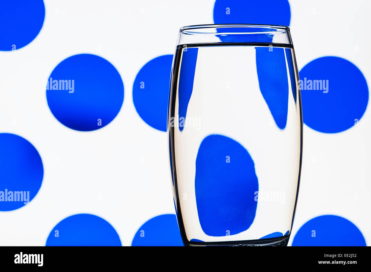 A tumbler of water against a patterned background to illustrate the refractive effect of water