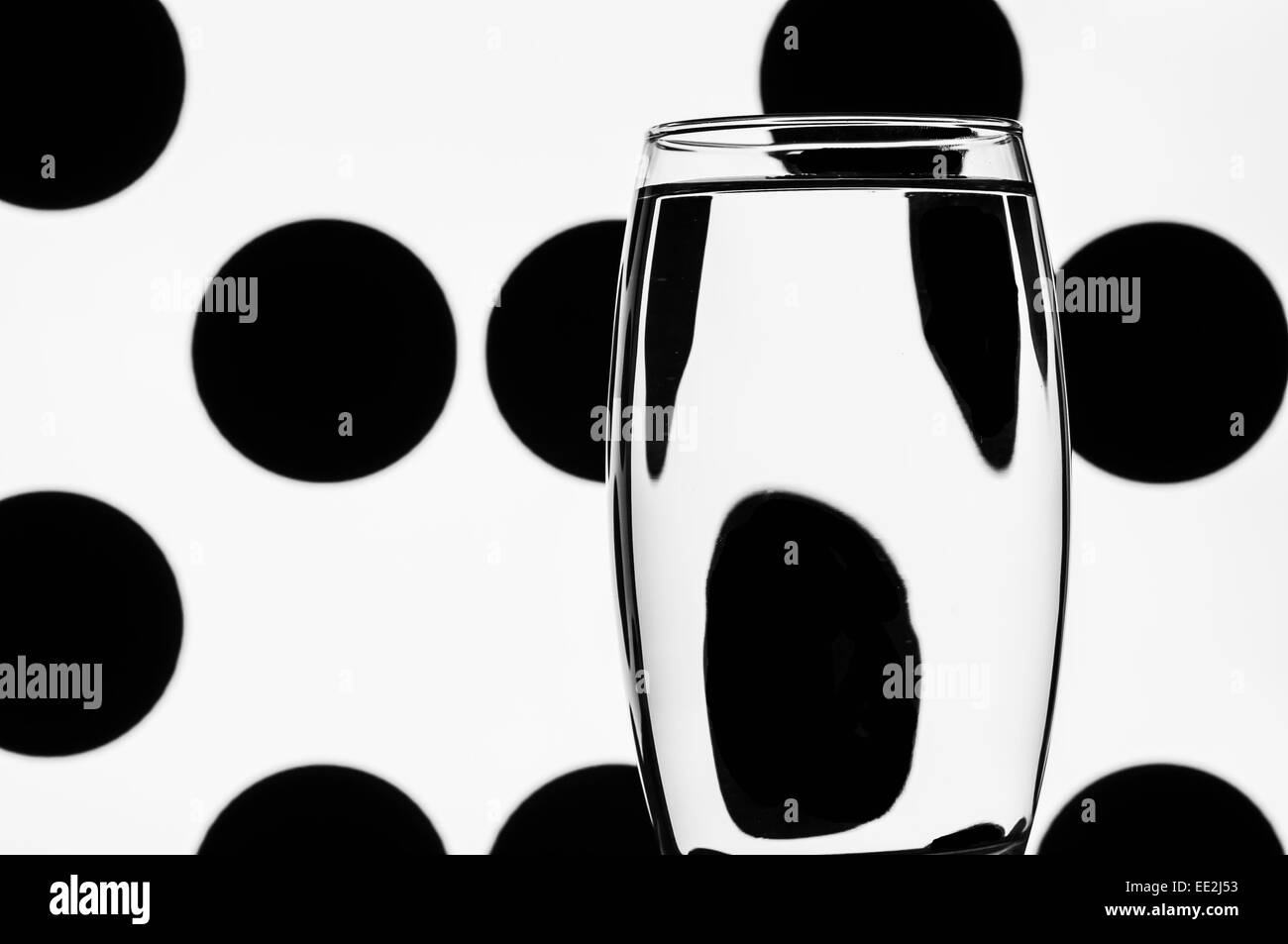 A tumbler of water against a patterned background to illustrate the refractive effect of water