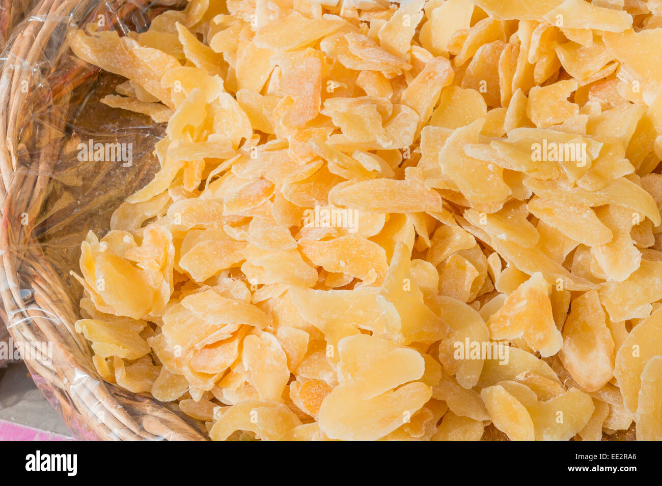 Candied and dried Crystallized Ginger slices in wicker bowl Stock Photo