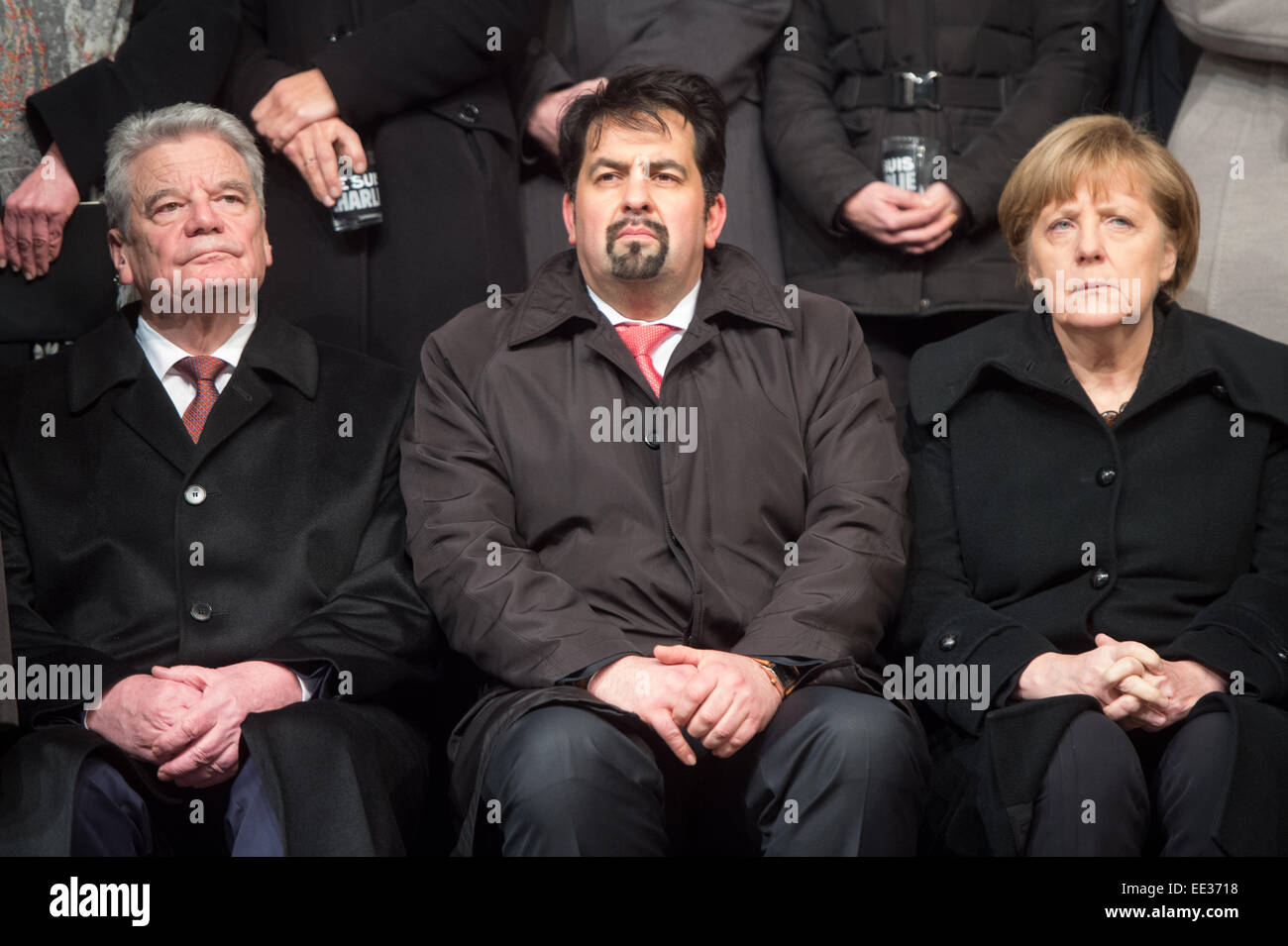 Berlin, Germany. 13th Jan, 2015. German President Joachim Gauck (L-R), chairman of the Central Committee of Muslims in Germany, Aiman Mazyek, and Chancellor Angela Merkel during a vigil for the victims of the attacks in France at the Brandenburg Gate in Berlin, Germany, 13 January 2015. The Central Committee of Muslims and the Turkish community have invoked the slogan 'Stand together - Show face' for the rally against Islamist terror and for the peaceful co-existence of the religions. Photo: MAURIZIO GAMBARINI/dpa/Alamy Live News Stock Photo