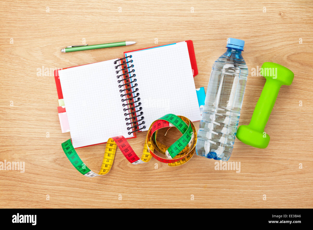 Dumbells, tape measure, water bottle and notepad for copy space