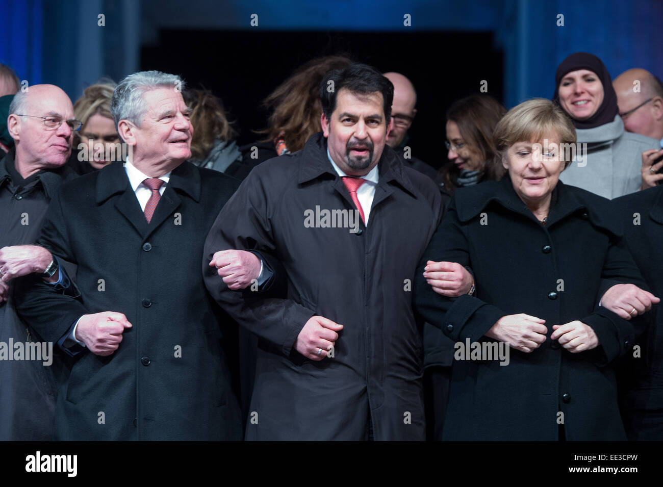 Berlin, Germany. 13th Jan, 2015. President of the Bundestag, Norbert Lammer (L-R), German President Joachim Gauck, chairman of the Central Committee of Muslims in Germany, Aiman Mazyek, and Chancellor Angela Merkel attend a vigil for the victims of the attacks in France at the Brandenburg Gate in Berlin, Germany, 13 January 2015. The Central Committee of Muslims and the Turkish community have invoked the slogan 'Stand together - Show face' for the rally against Islamist terror and for the peaceful co-existence of the religions. Photo: MAURIZIO GAMBARINI/dpa/Alamy Live News Stock Photo