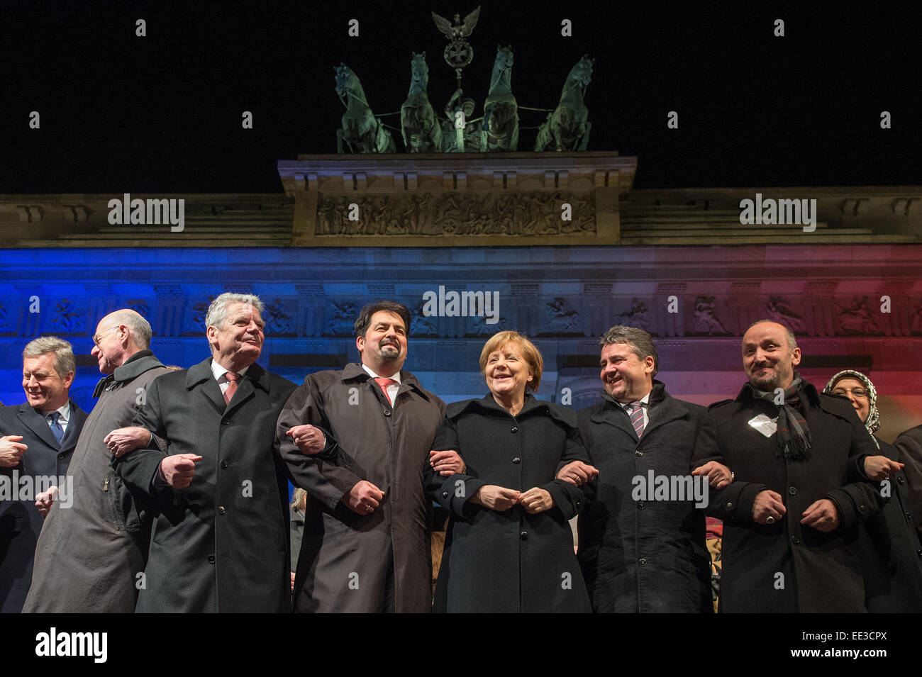 Berlin, Germany. 13th Jan, 2015. Former German President Christian Wulff, (L-R) President of the Bundestag, Norbert Lammer, German President Joachim Gauck, chairman of the Central Committee of Muslims in Germany, Aiman Mazyek, Chancellor Angela Merkel, Minister of Economic Affairs Sigmar Gabirel, and the chairman of the Turkish Community in Berlin, Bekir Yilmaz, attend a vigil for the victims of the attacks in France at the Brandenburg Gate in Berlin, Germany, 13 January 2015. Stock Photo