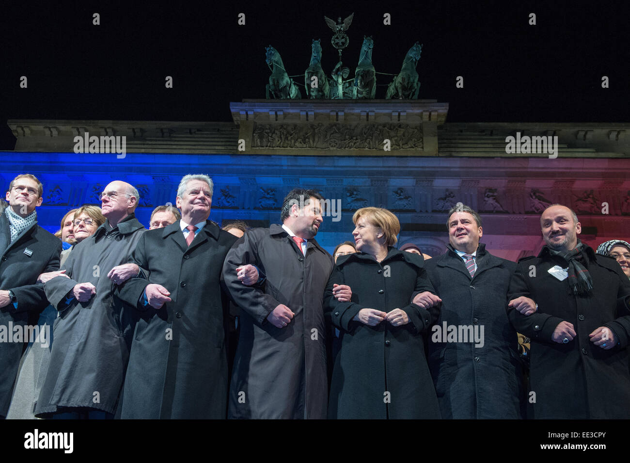 Berlin, Germany. 13th Jan, 2015. Mayor of Berlin Michael Mueller, (L-R) President of the Bundestag, Norbert Lammer, German President Joachim Gauck, chairman of the Central Committee of Muslims in Germany, Aiman Mazyek, Chancellor Angela Merkel, Minister of Economic Affairs Sigmar Gabirel, and the chairman of the Turkish Community in Berlin, Bekir Yilmaz, attend a vigil for the victims of the attacks in France at the Brandenburg Gate in Berlin, Germany, 13 January 2015. The Central Committee of Muslims and the Turkish community have invoked the slogan 'Stand together - Show face' for the rally. Stock Photo