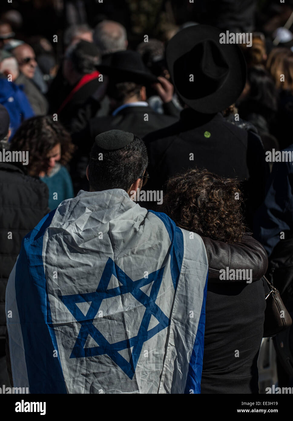 Jeruslaem, Israel. 13th Jan, 2015. A man with the Israeli national flag on his shoulders attends a funeral ceremony for the four victims of Paris supermarket attack at Givat Shaul cemetery, on the outskirts of Jerusalem, on Jan. 13, 2015. Israeli leaders and multitude of mourners gathered Tuesday with the families of four Jewish victims of last week's terror attack on a Paris kosher supermarket for a solemn funeral ceremony at a Jerusalem cemetery. Yoav Hattab, Yohan Cohen, Philippe Braham and Francois-Michel Saada, were gunned down on Friday during a hostage attack on 'Hyper Cas © Xinhua/Alam Stock Photo