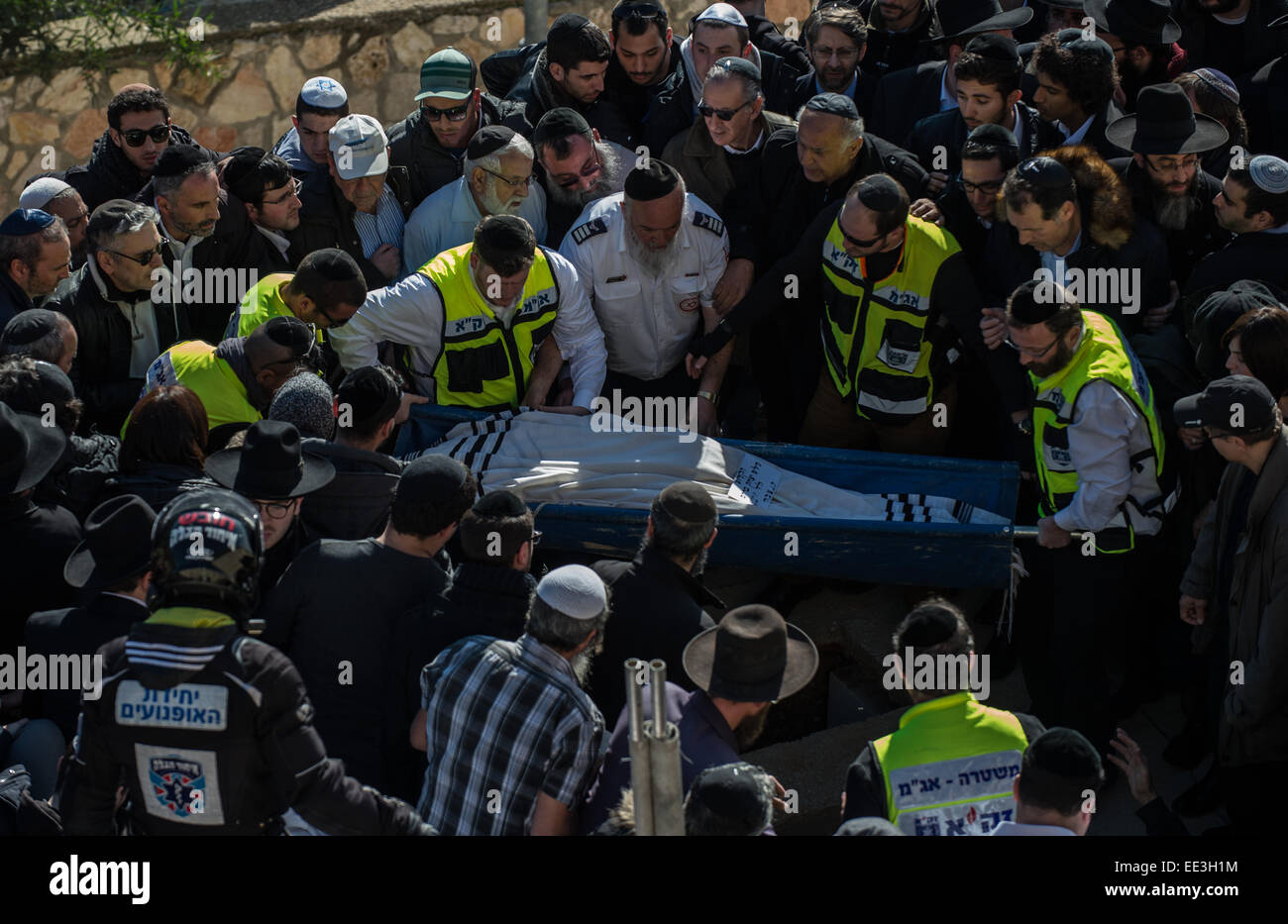 Jeruslaem, Israel. 13th Jan, 2015. A body of victim of Paris supermarket attack is carried to the grave during a funeral ceremony at Givat Shaul cemetery, on the outskirts of Jerusalem, on Jan. 13, 2015. Israeli leaders and multitude of mourners gathered Tuesday with the families of four Jewish victims of last week's terror attack on a Paris kosher supermarket for a solemn funeral ceremony at a Jerusalem cemetery. Yoav Hattab, Yohan Cohen, Philippe Braham and Francois-Michel Saada, were gunned down on Friday during a hostage attack in Paris.market in eastern Paris. Credit:  Xinhua/Alamy Live N Stock Photo