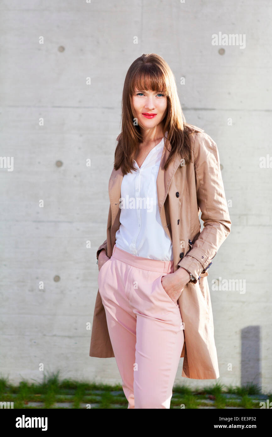 Young woman with hands in pockets standing outdoors, Munich, Bavaria, Germany Stock Photo