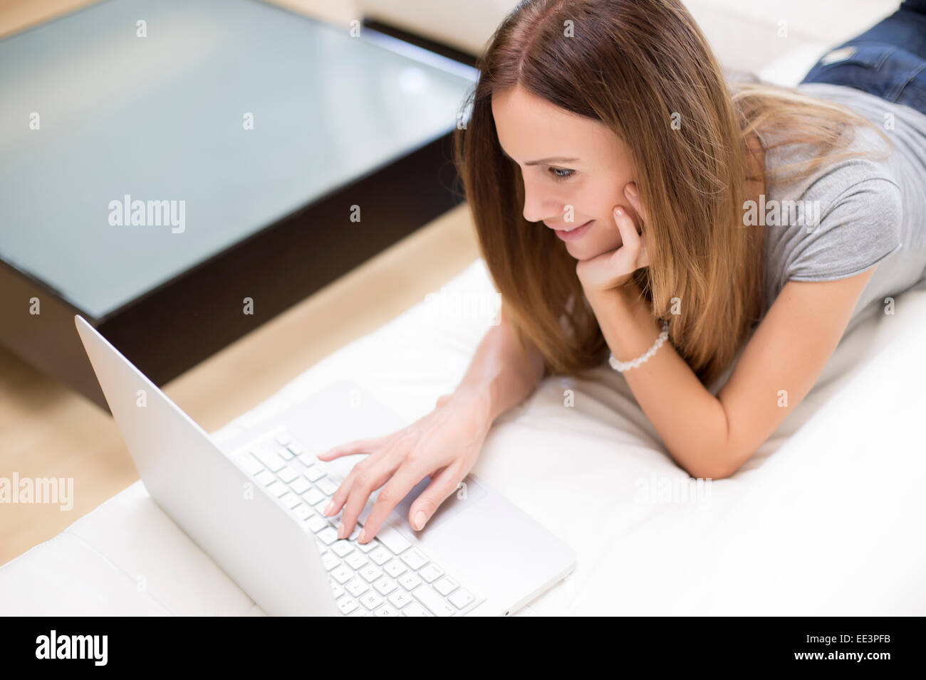 Young woman working on laptop in the room Stock Photo - Alamy