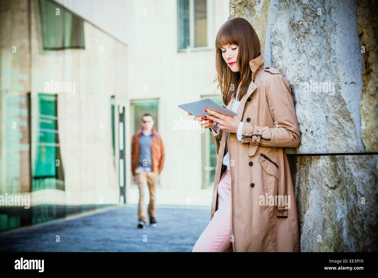 Young woman using digital tablet outdoors, Munich, Bavaria, Germany Stock Photo