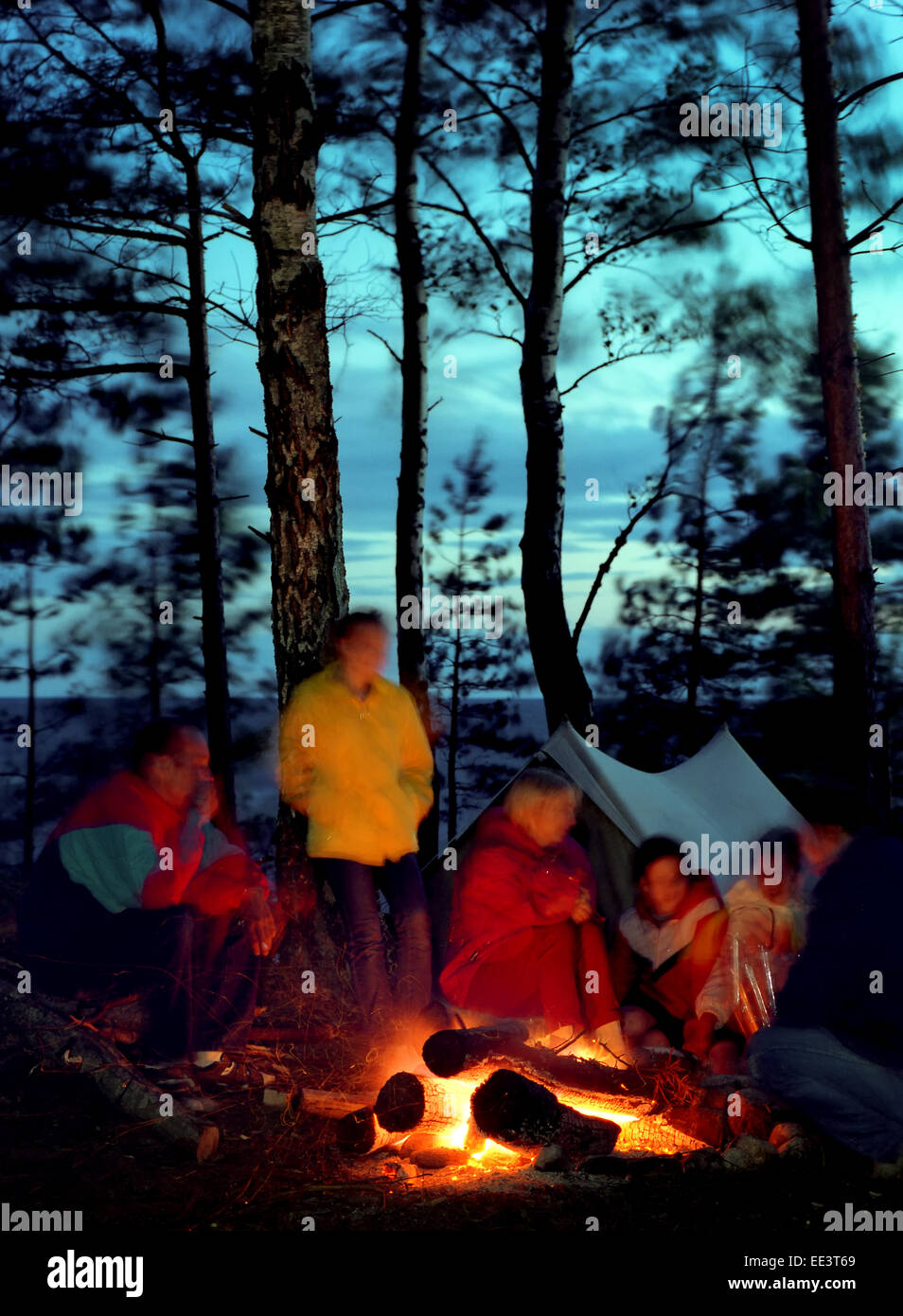 Tourists bonfire. People seating around of fire. Stock Photo