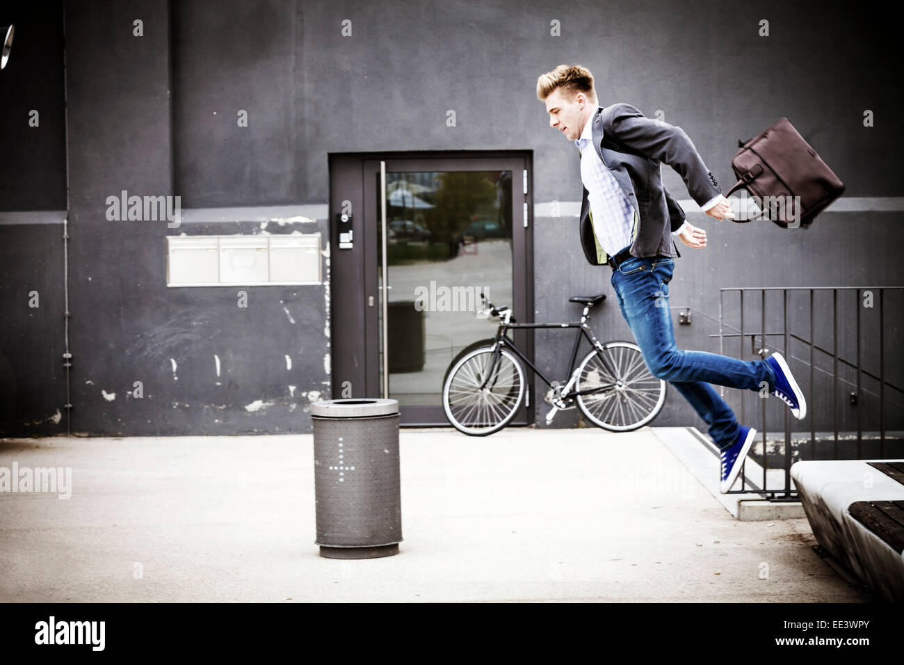 Young businessman jumping in air, Munich, Bavaria, Germany Stock Photo