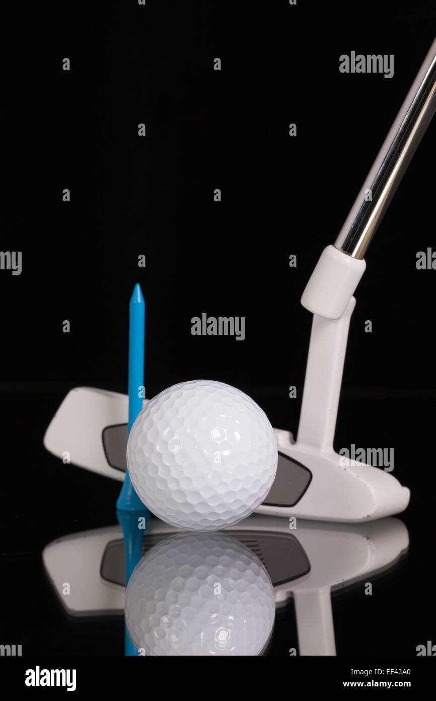 Golf putter and different golf equipments on the black glass desk Stock Photo