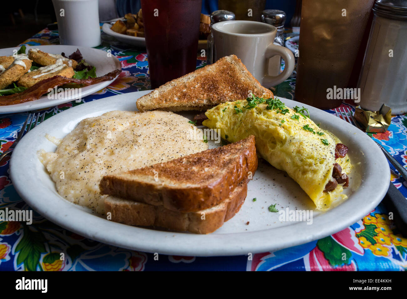 New Orleans, Louisiana.  Bacon and Sausage Omelet, Toast and Grits, Breakfast at Elizabeth's Restaurant, Bywater District. Stock Photo