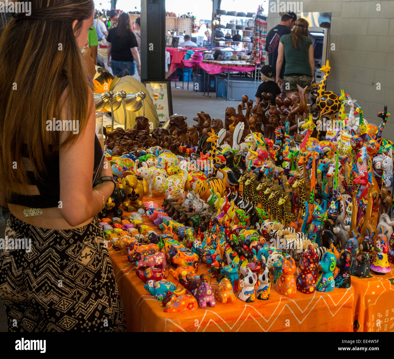French Quarter, New Orleans, Louisiana.  Tourist Considering Hand-painted Carved Toy Animals for Sale in the French Market. Stock Photo