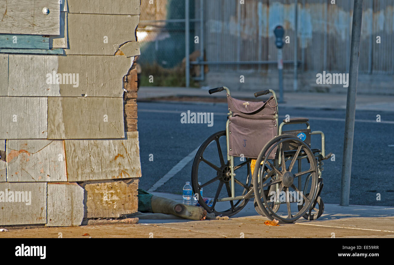 Homeless Person with Injured Leg on Ground Next to Wheelchair, East ...