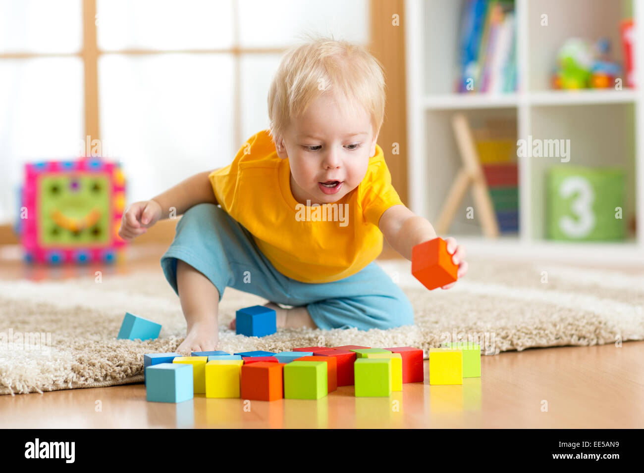 child toddler playing wooden toys at home Stock Photo