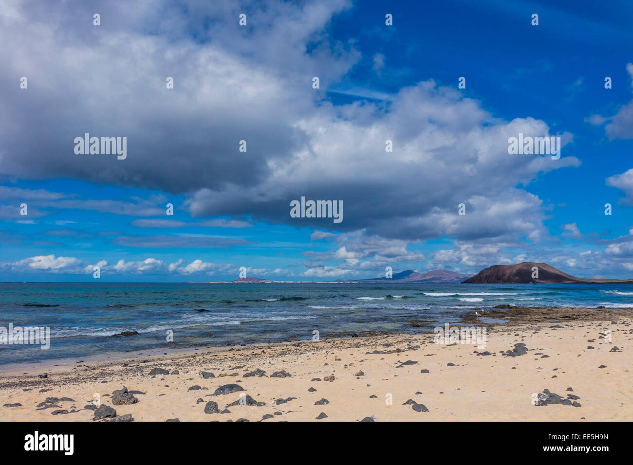 View of Lobos from Corralejo beach with dramatic cloud formation in a blue sky Canary islands  Fuerteventura Spain Stock Photo