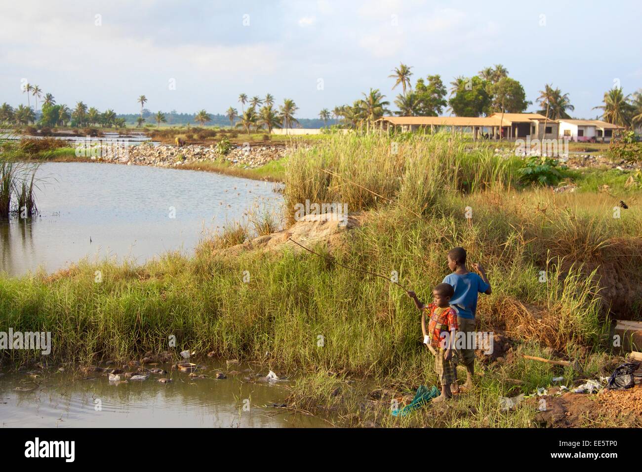 Children fishing in dirty water Ghana Stock Photo