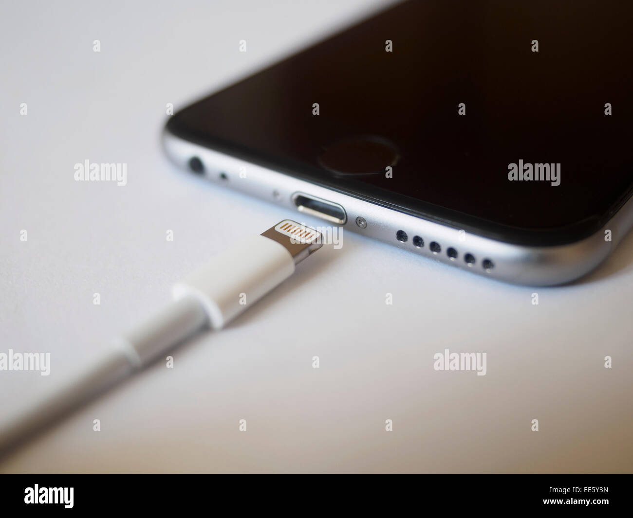 Selective focus photo of the charging cable and lightning port connector of an Apple iPhone 6 smartphone Stock Photo