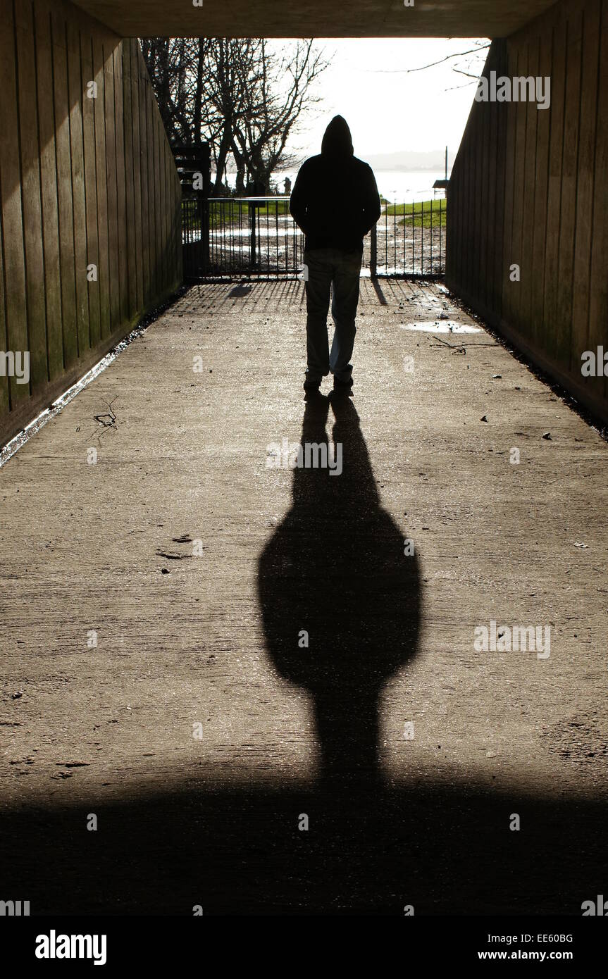 Hooded man walks through underpass/tunnel Stock Photo - Alamy