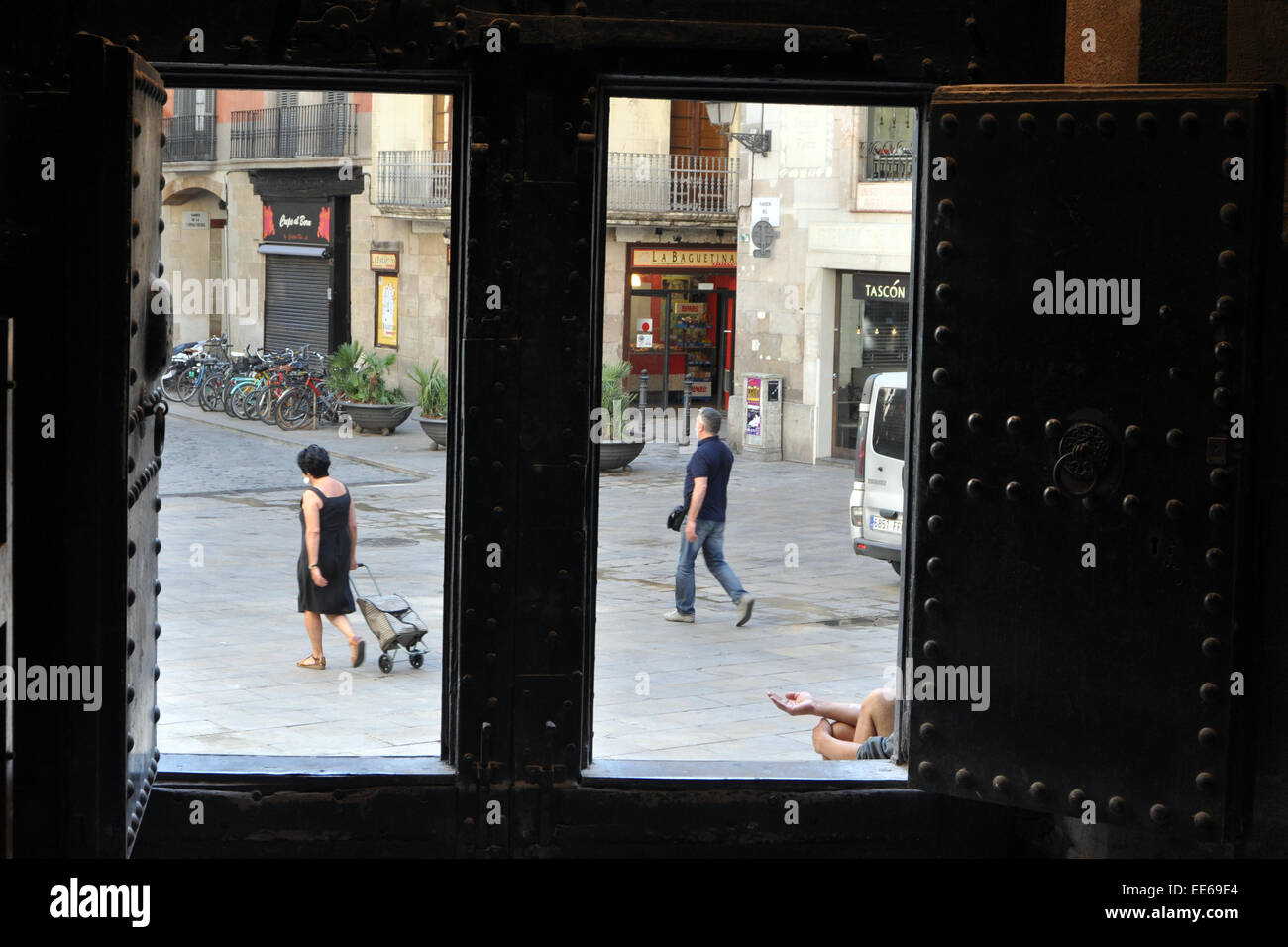 A beggar sits in the door way of a church,  Barcelona. Basílica de la Mercé Spain Stock Photo