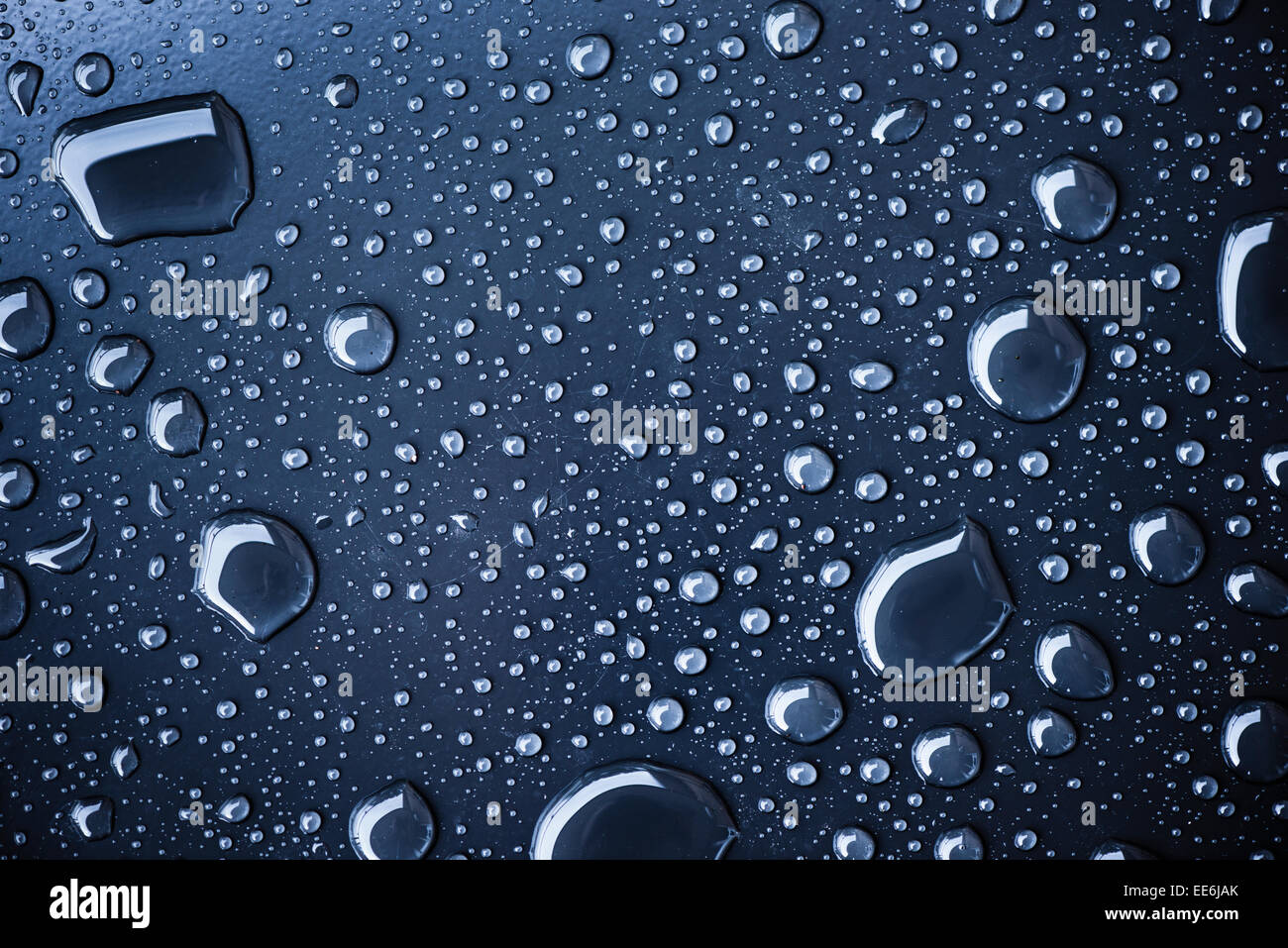 Close up of water drops on dark metallic surface Stock Photo