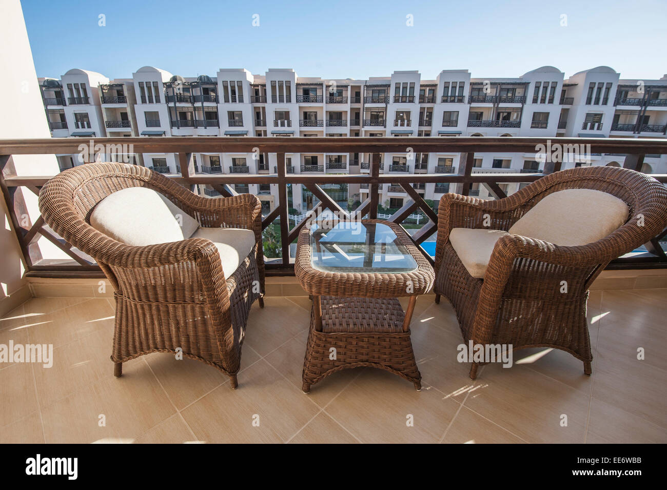 Wicker bamboo chairs and table on tropical apartment balcony Stock Photo