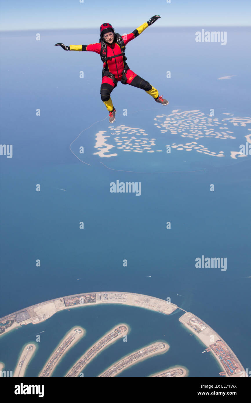 Skydiver is having fun and stand up flying free with a speed of 120 mph at 10'000 ft altitude over the Dubai Palm beaches. Stock Photo