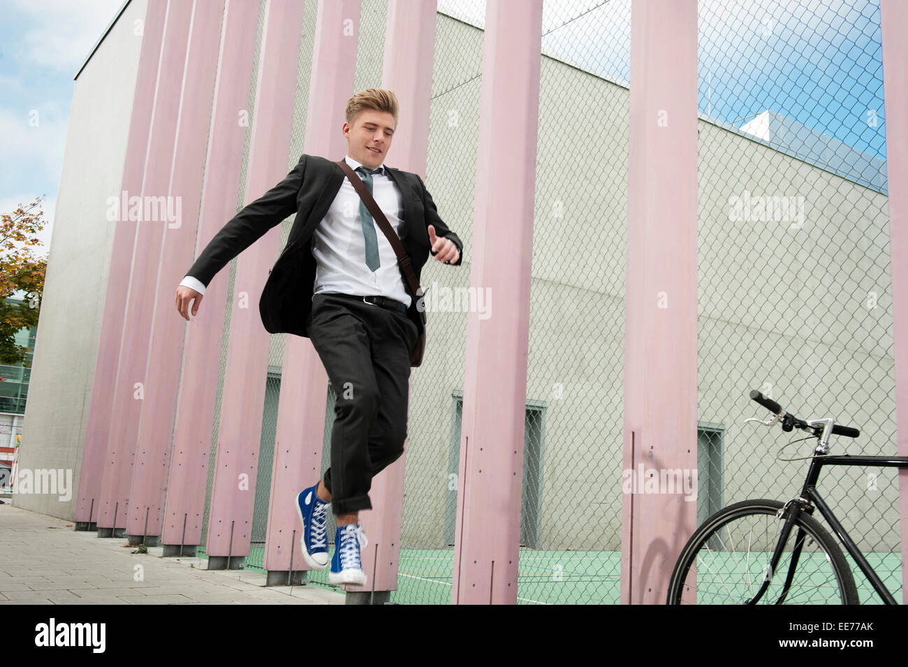 Young businessman jumping in air, Munich, Bavaria, Germany Stock Photo