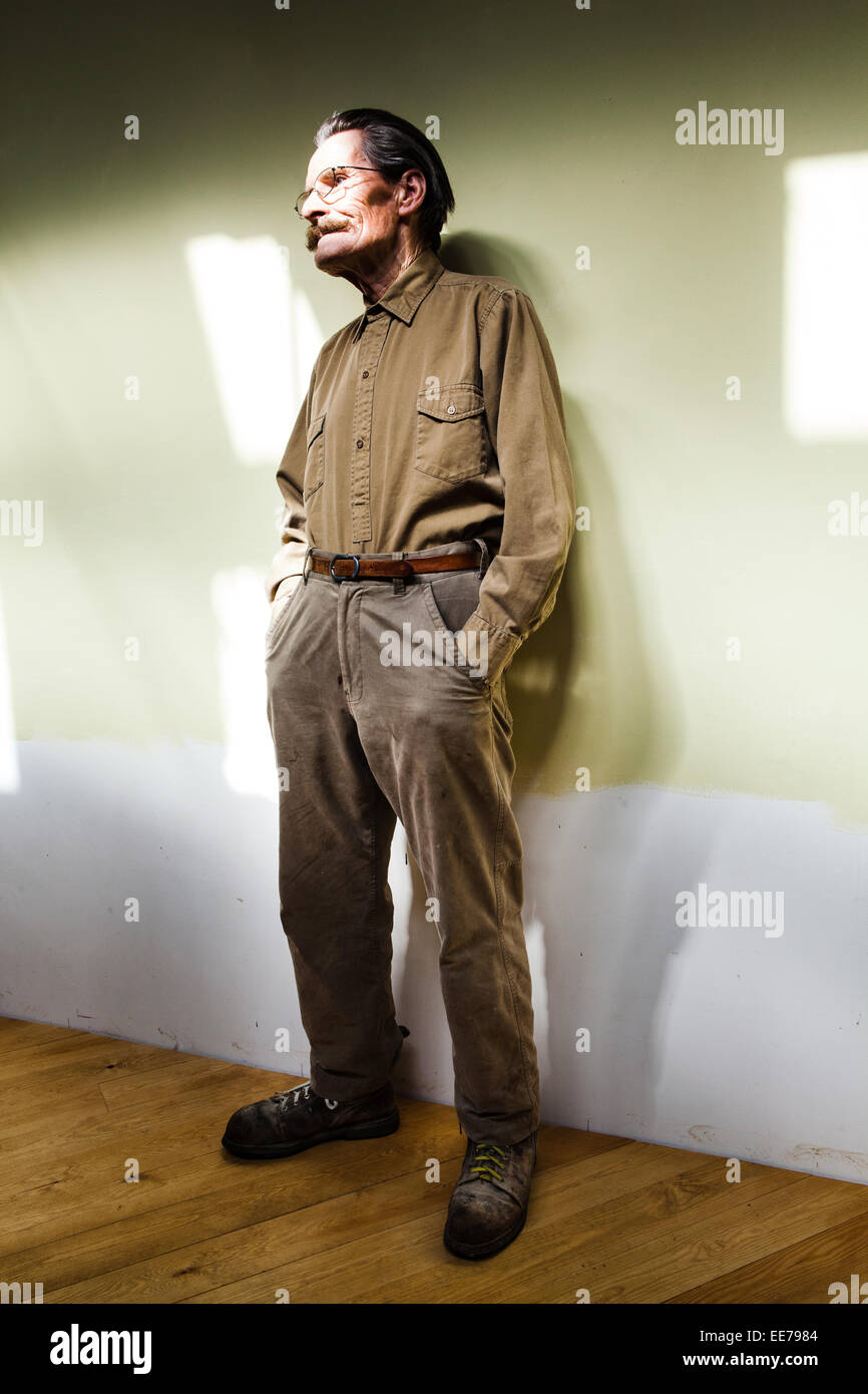 Man in his 60s with moustache wearing khaki shirt and trousers. Stock Photo