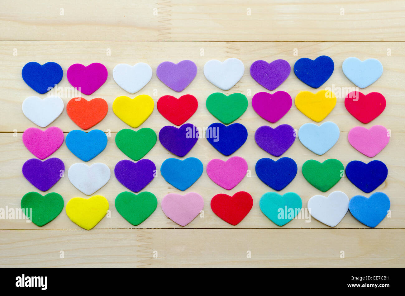 Lots of colorful paper hearts on a wooden table Stock Photo
