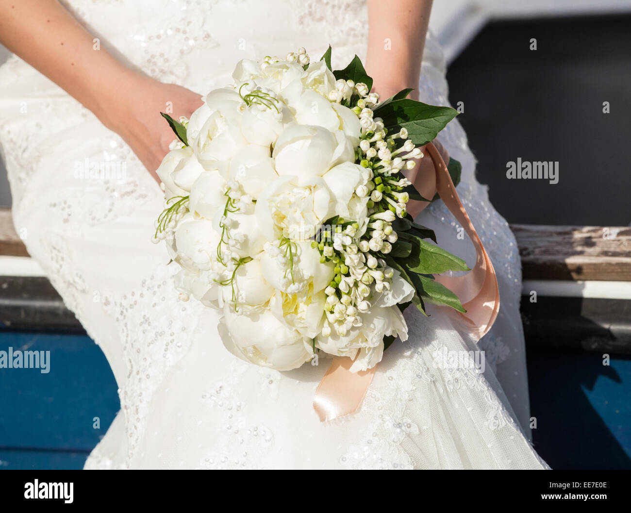 Bride holding wedding bouquet with white peonies Stock Photo - Alamy