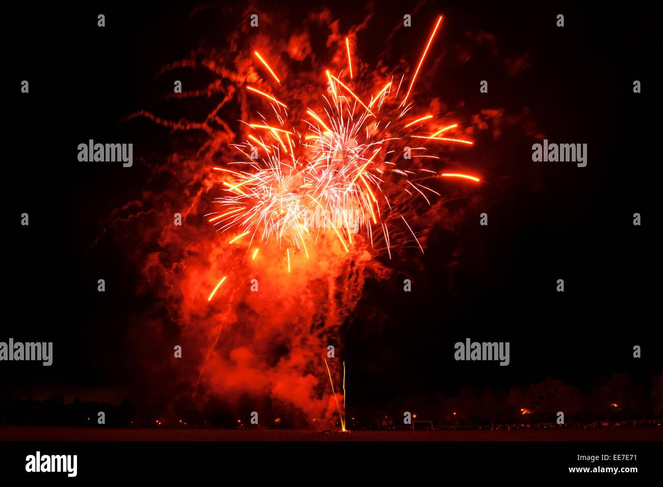 Fireworks as part of a public show at the Bught Park, Inverness.  Red and white fireworks explode against a black, night sky. Stock Photo