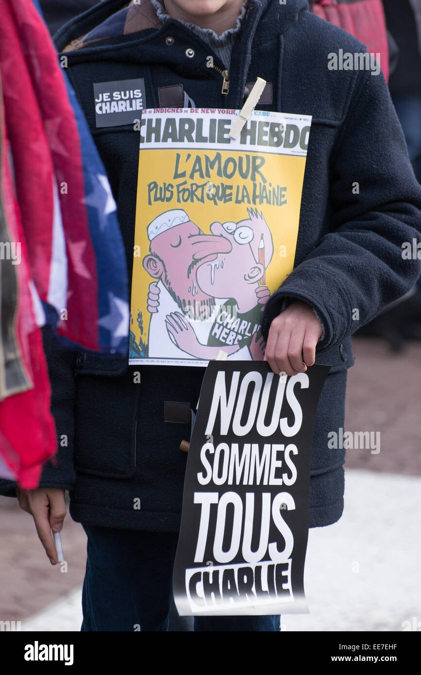 A young man with a slogan and charlie Hebdo cover during gathering 'Je Suis Charlie' vigil at Laval city, Jet d'eau Square, su Stock Photo