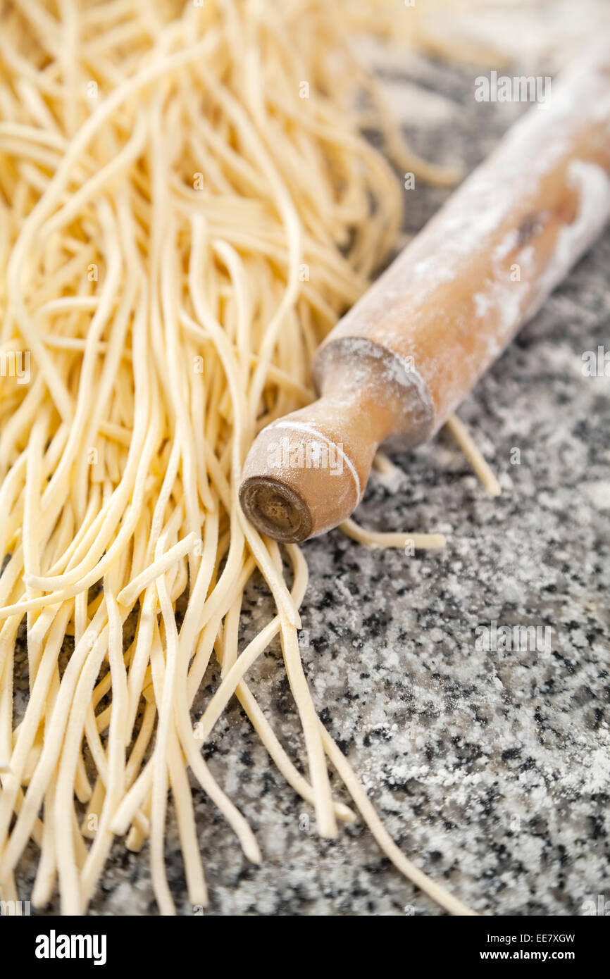 Boiled Spaghetti Pasta With Rolling Pin On Marble Counter Stock Photo