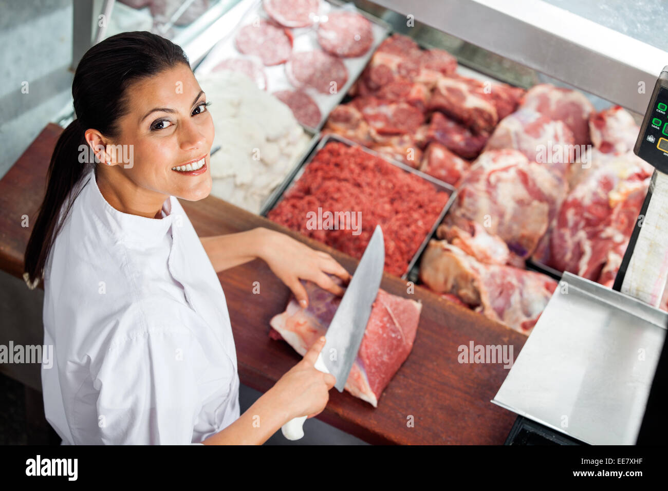 Happy Female Butcher Cutting Meat At Butchery Stock Photo Alamy