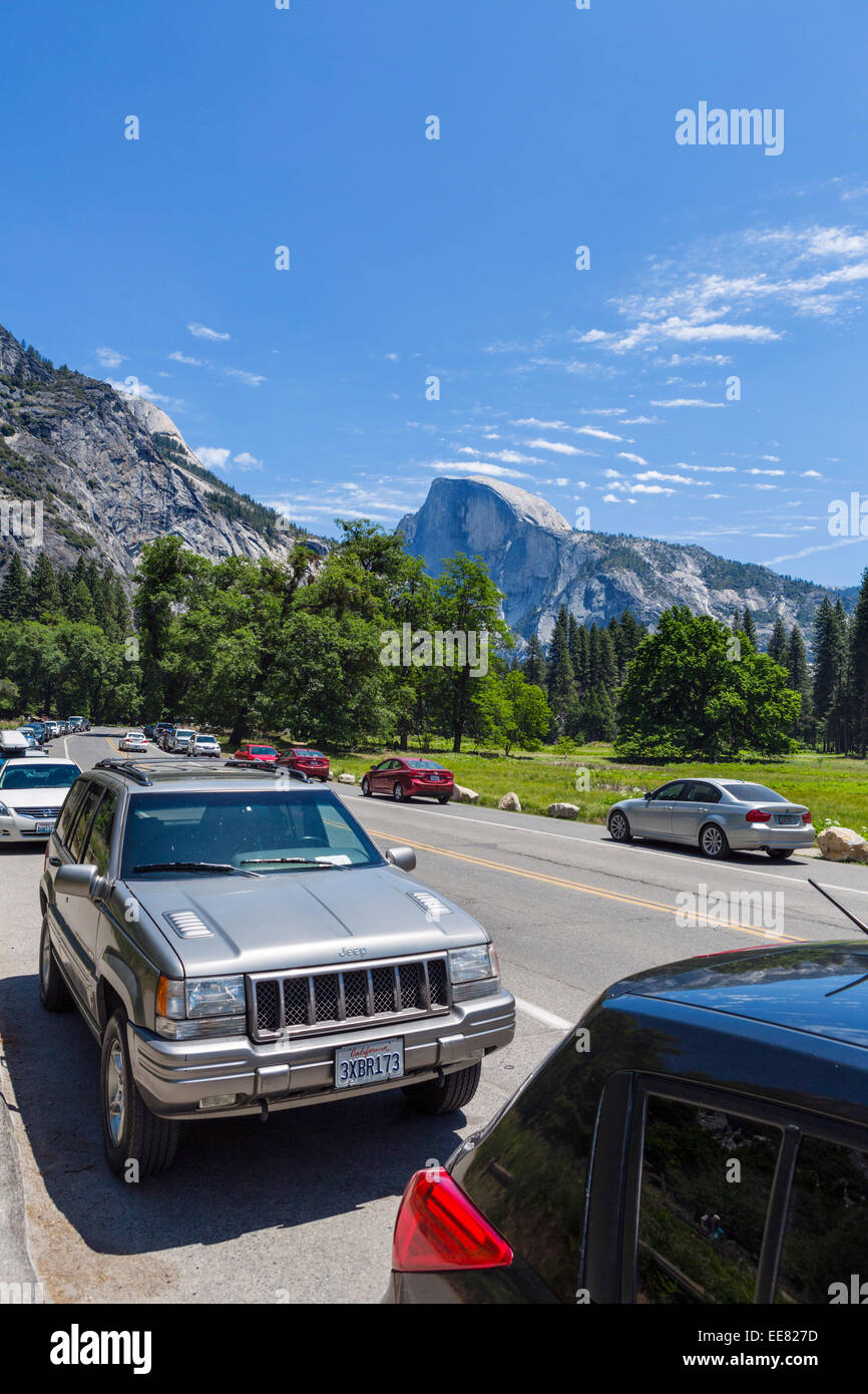 Cars parked on Northside Dr nr Yosemite Falls with Half Dome in distance, Yosemite Valley, Yosemite National Park, CA, USA Stock Photo