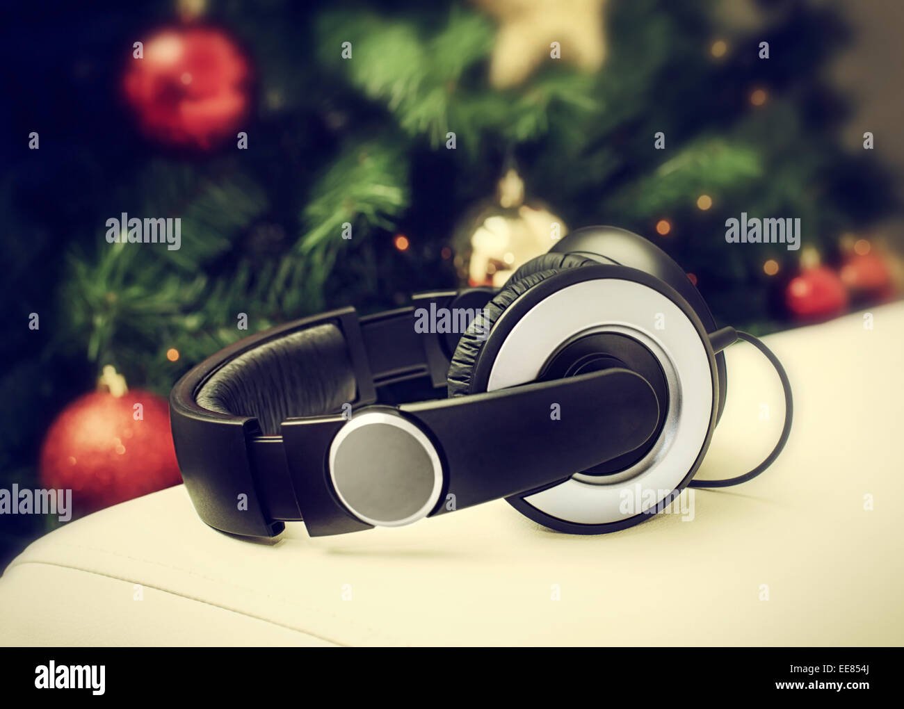 Headphones resting on a white leather sofa near the Christmas tree