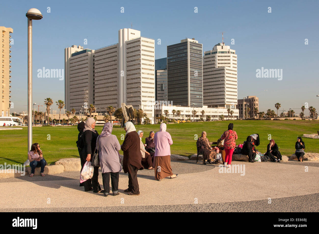 Israeli-Arab women in a family day out, sitting along the promenade in Tel Aviv, Israel Stock Photo