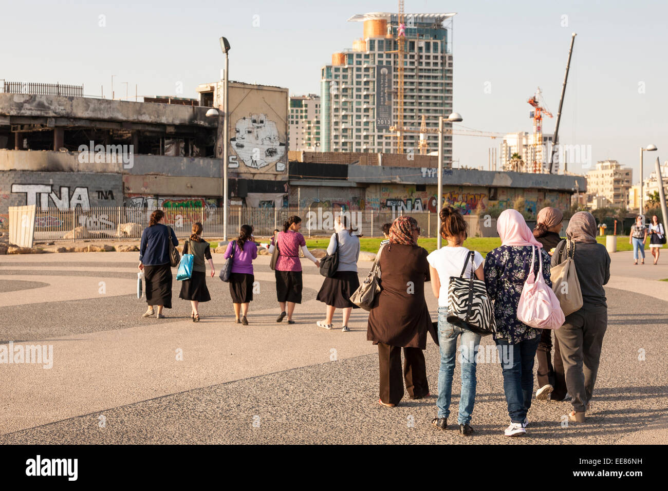 groups of Arab and Israeli women walking along the seafront in Tel Aviv, Israel Stock Photo