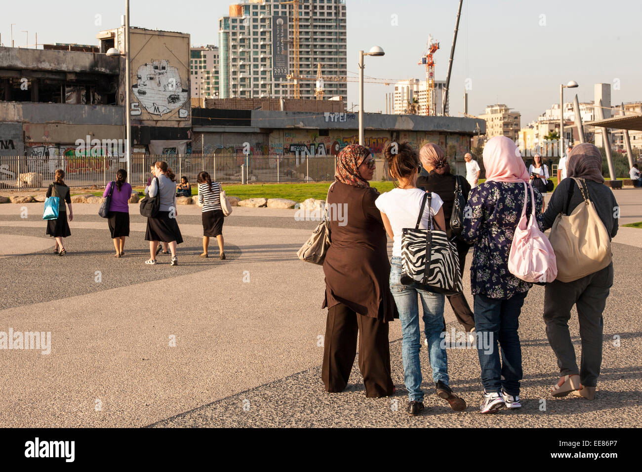 groups of Arab and Israeli women walking along the seafront in Tel Aviv, Israel Stock Photo