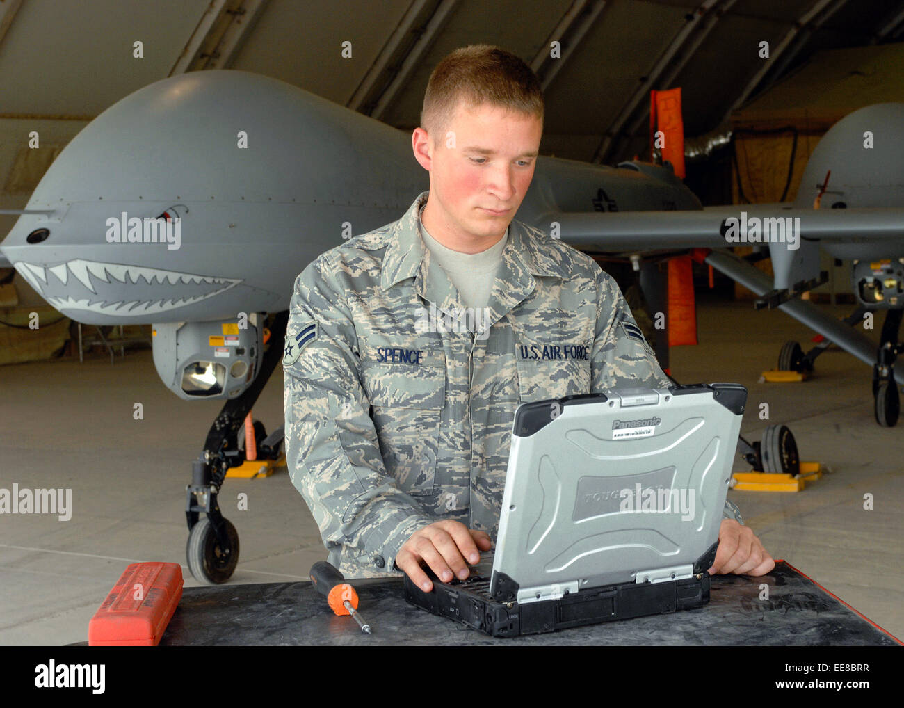 Airman 1st Class Troy Spence, 62nd Expeditionary Reconnaissance Squadron performs maintenance on a MQ-1 Predator UAV at Bagram Air Base, Afghanistan in support of Operation Enduring Freedom. See description for more information. Stock Photo