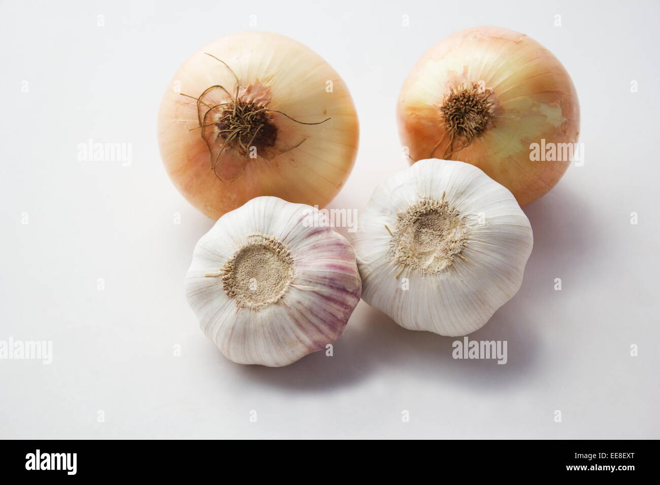 Two onions and two heads of garlic on white background Stock Photo - Alamy