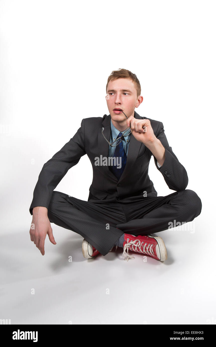 young man in a gray jacket and red sneakers on a white background Stock Photo