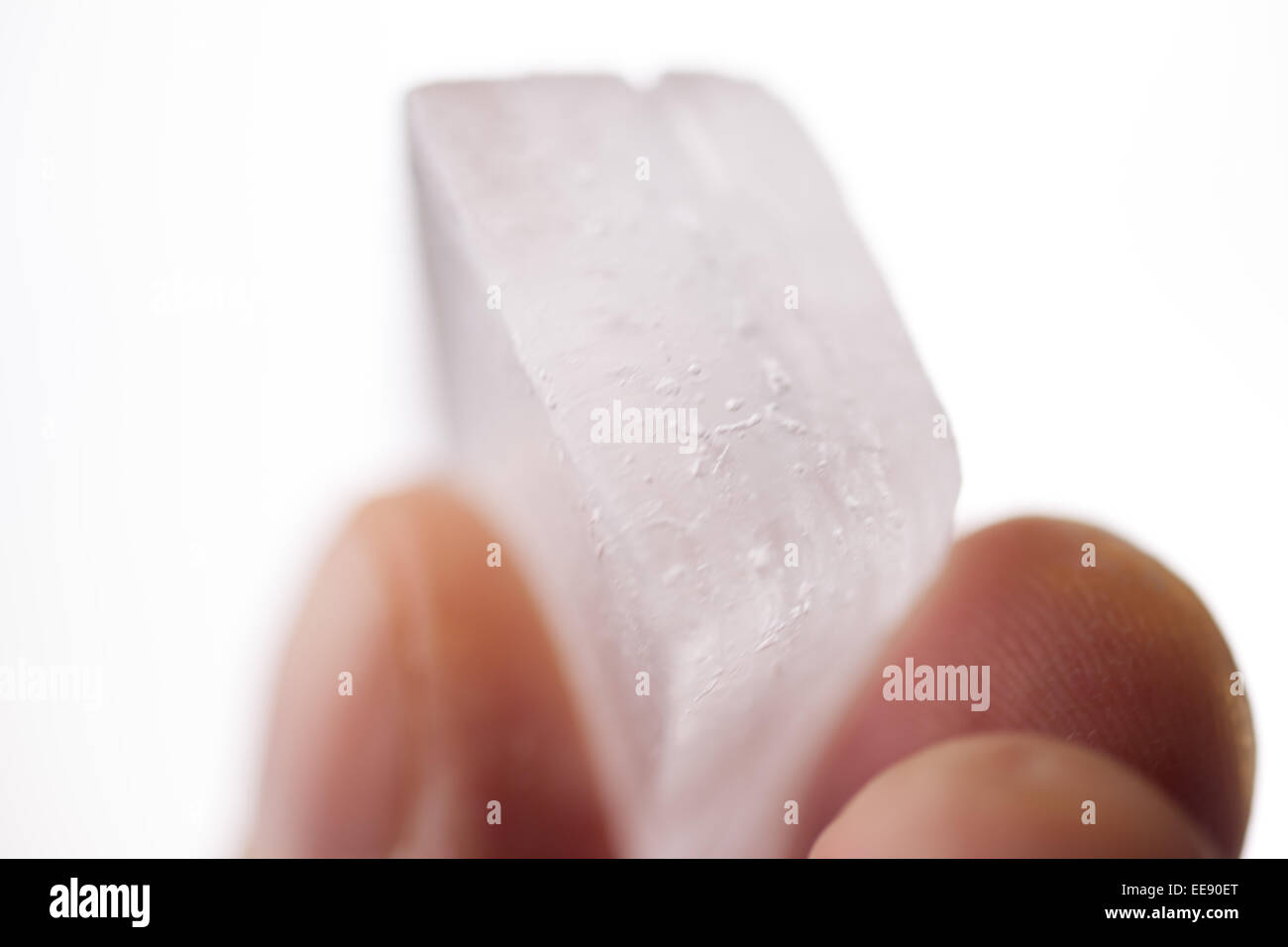 Holding an ice cube in the fingers. Stock Photo