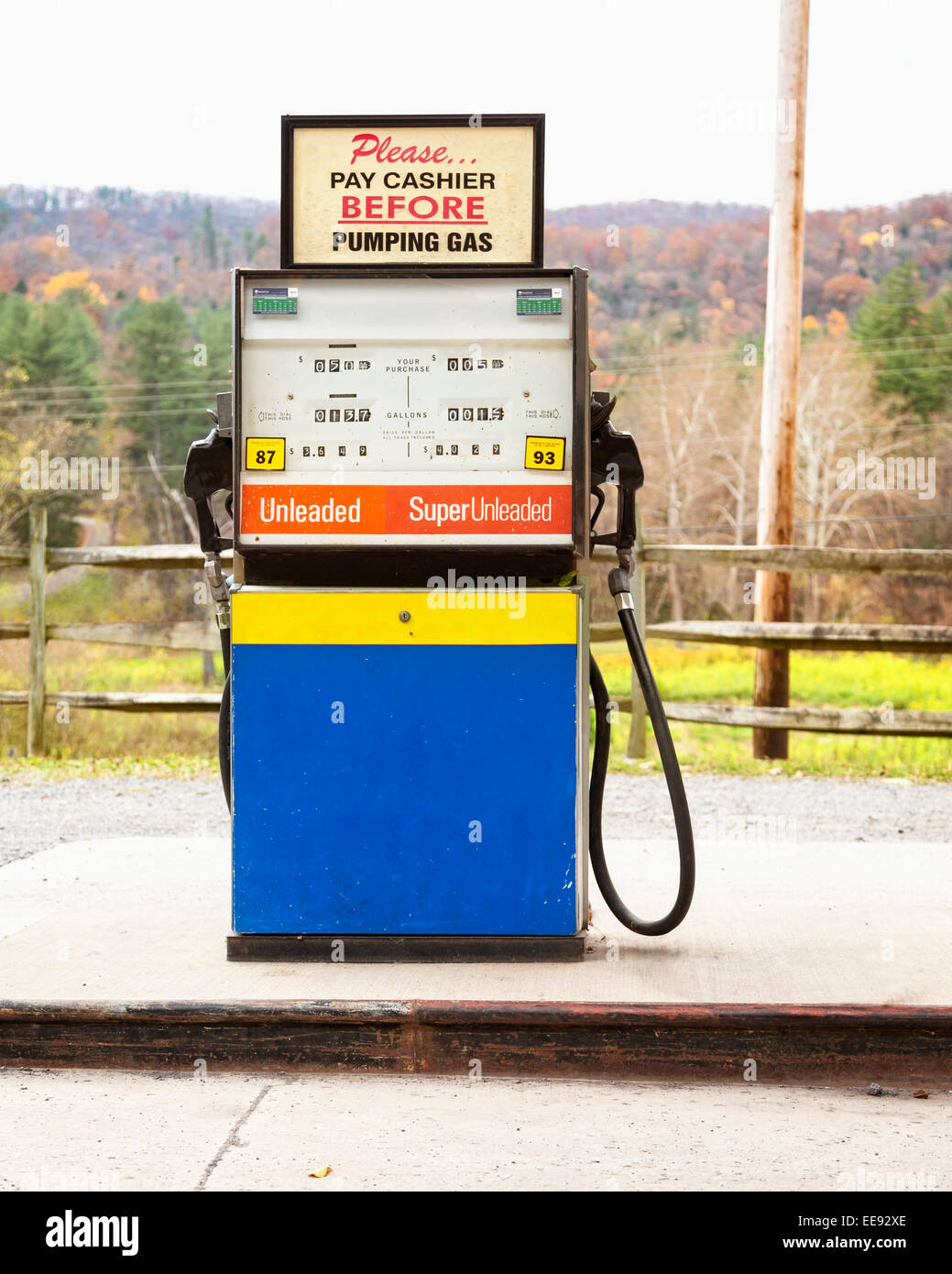 Close up of gas pump with fall trees and fence in background Stock Photo