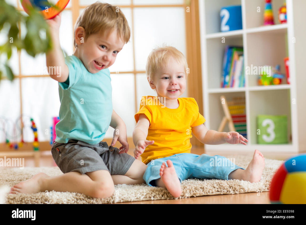 kids playing with ball in playroom Stock Photo