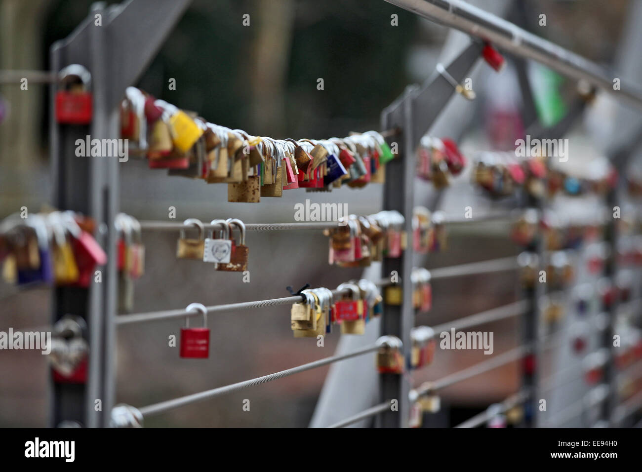 Nuremberg, Germany. 14th Jan, 2015. Countless padlocks hang on a footbridge in the city centre of Nuremberg, Germany, 14 January 2015. In the old days, couples carved teir initials into trees or park banks. Today, they hang a colourful padlock onto a bridge and throw the keys into the river. The weight of the locks is becoming a problem for the statics of these constructions. PHOTO: DANIEL KARMANN/dpa/Alamy Live News Stock Photo